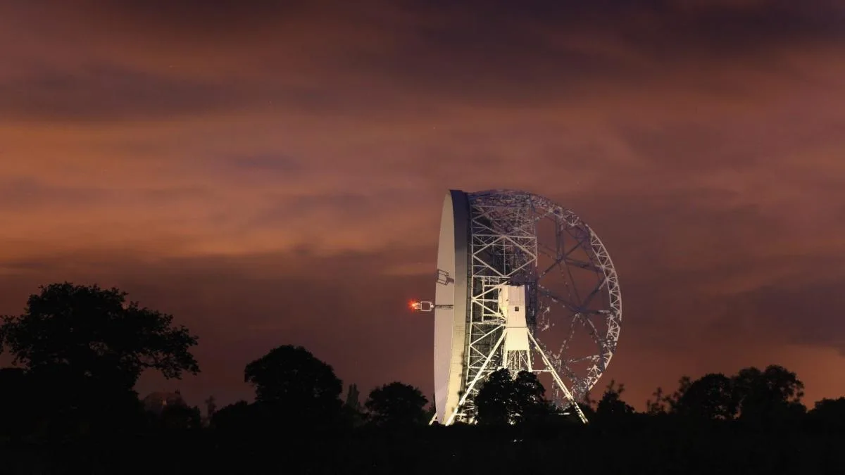 Un radiotelescop în noapte, captând semnale din univers.