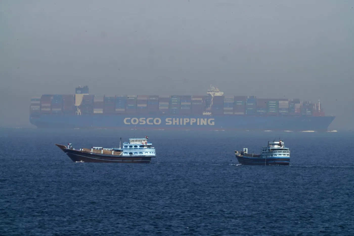 Vapor cargo navigând în Strâmtoarea Ormuz, cu alte bărci în apropiere.
