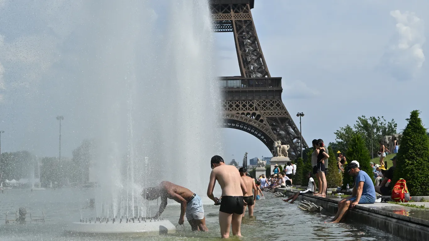 Oameni răcorindu-se în fântână lângă Turnul Eiffel în timpul valului de căldură.