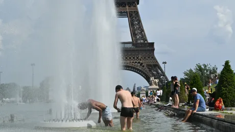 Oameni răcorindu-se în fântână lângă Turnul Eiffel în timpul valului de căldură.