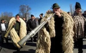 Crescători de oi protestând cu instrumente tradiționale în stradă.