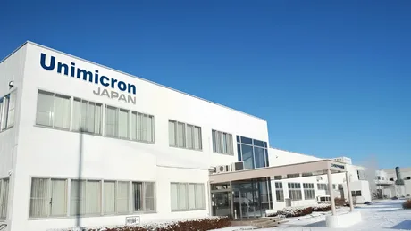 Clădirea Unimicron din Japonia, cu un cer senin și zăpadă.