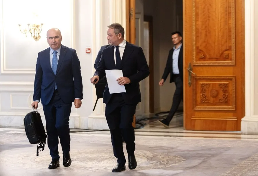Doi politicieni discută în holul unei clădiri oficiale.
