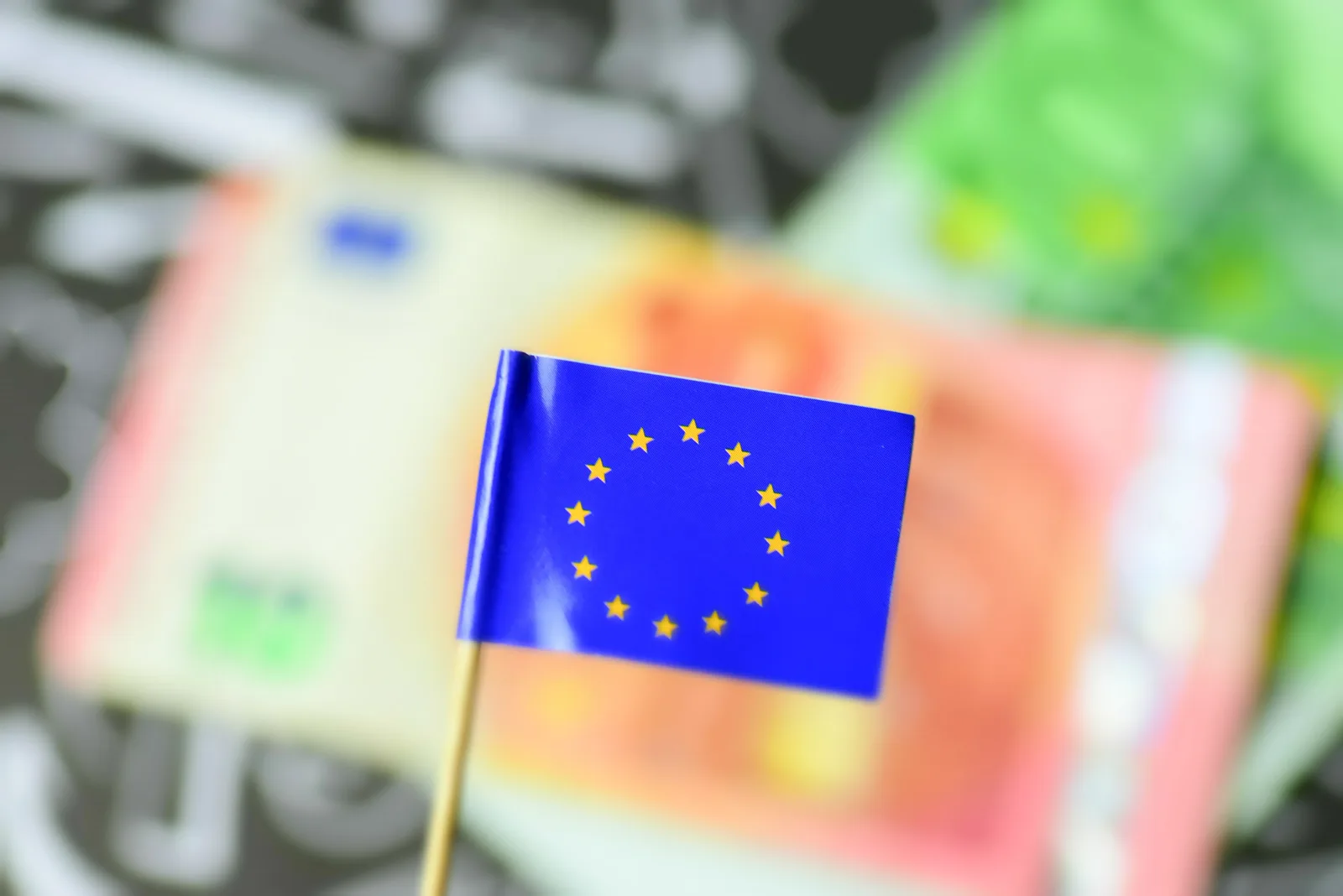 Steag al Uniunii Europene pe fundal de bancnote colorate.