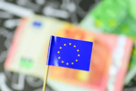 Steag al Uniunii Europene pe fundal de bancnote colorate.