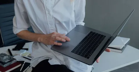 O persoană folosește un laptop pentru a accesa servicii online.