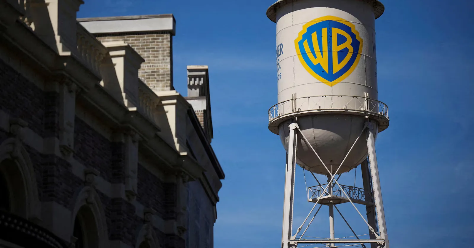 Logo-ul Warner Bros pe un rezervor de apă, simbol al fuziunii media.