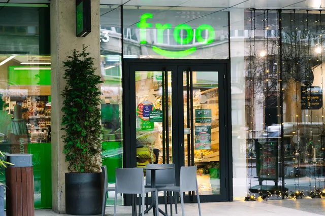 Magazin Froo cu uși de sticlă și logo verde, situat într-o zonă urbană.