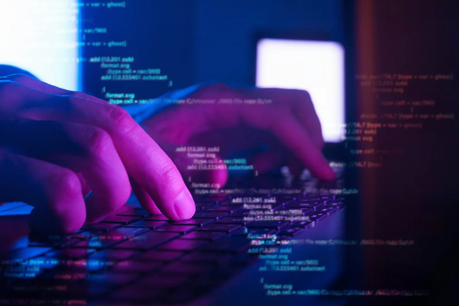 Mâini care tastează pe o tastatură, cu coduri de programare pe ecran.