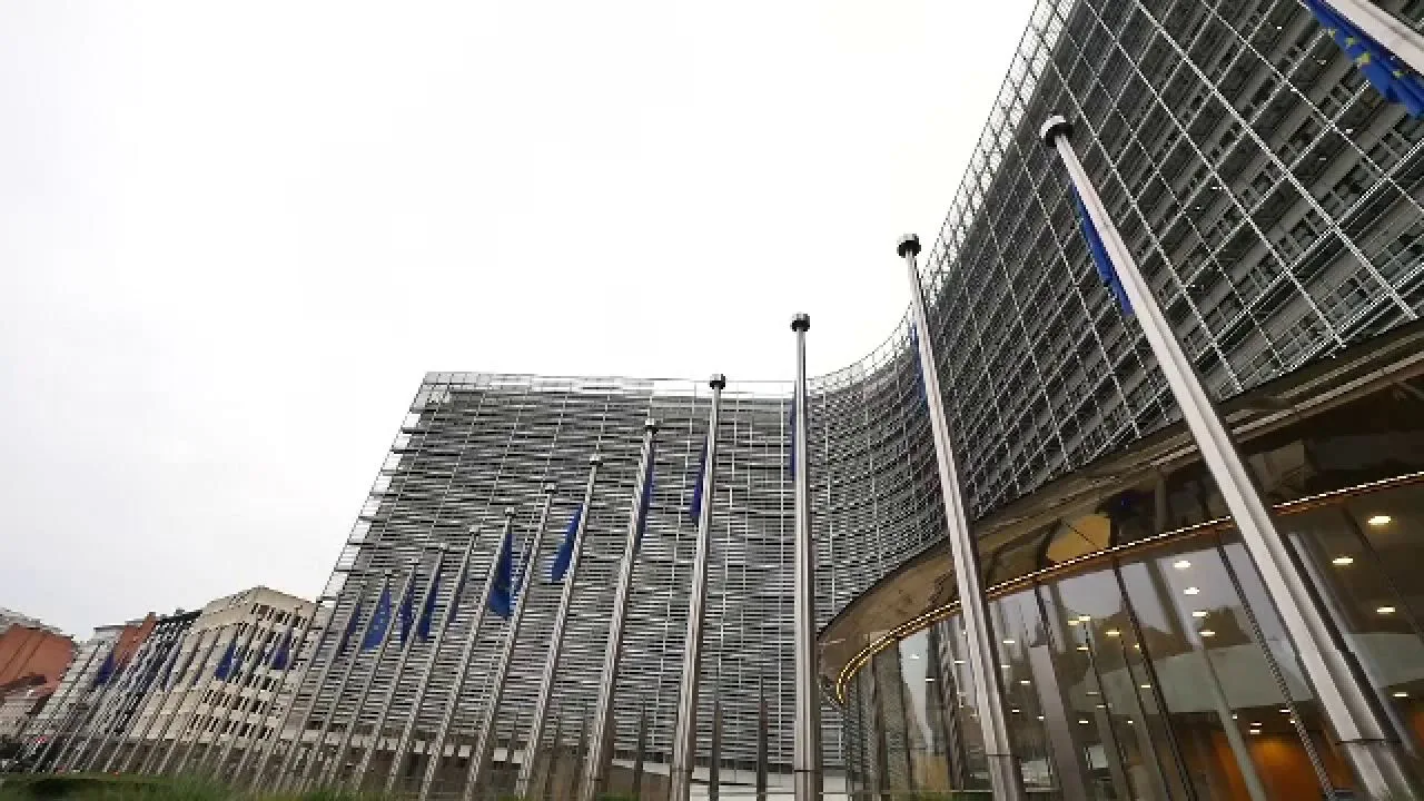 Clădire modernă cu steaguri europene în față, simbol al cooperării internaționale.