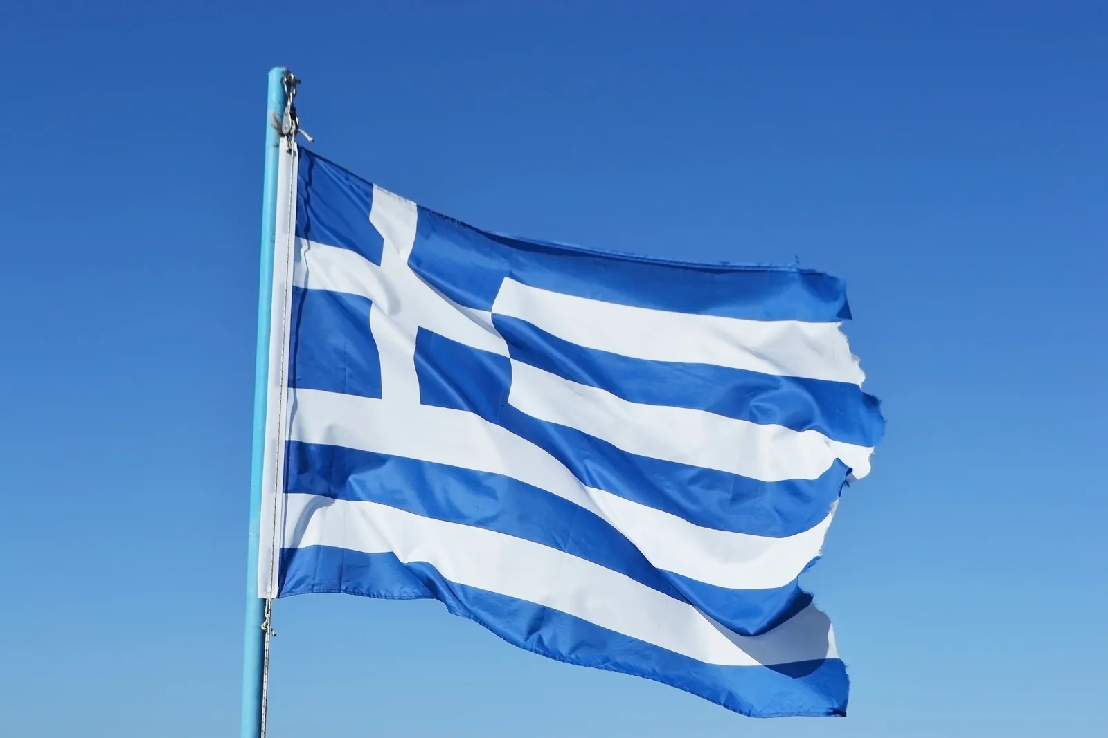 Steagul Greciei fluturând pe un fundal albastru senin.