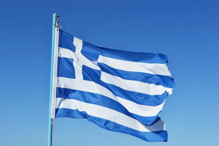 Steagul Greciei fluturând pe un fundal albastru senin.
