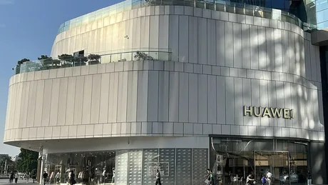 Clădire modernă cu logo-ul Huawei pe fațadă, în oraș.