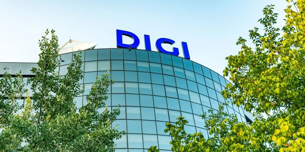 Clădire Digi cu logo pe fond de cer albastru și copaci verzi.