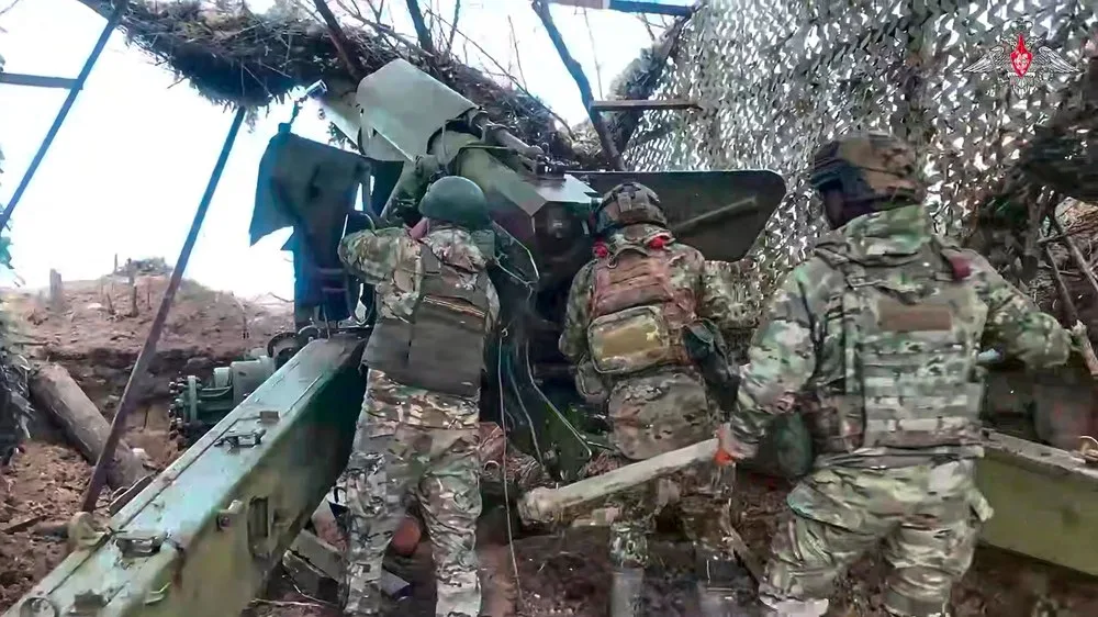 Soldați pregătind echipamente militare într-un peisaj de război.