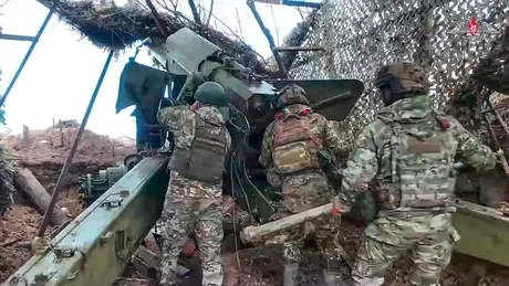 Soldați pregătind echipamente militare într-un peisaj de război.
