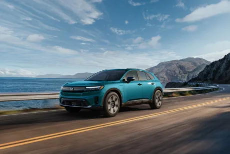 Honda lansează un nou model electric pe drum, cu peisaj montan în fundal.