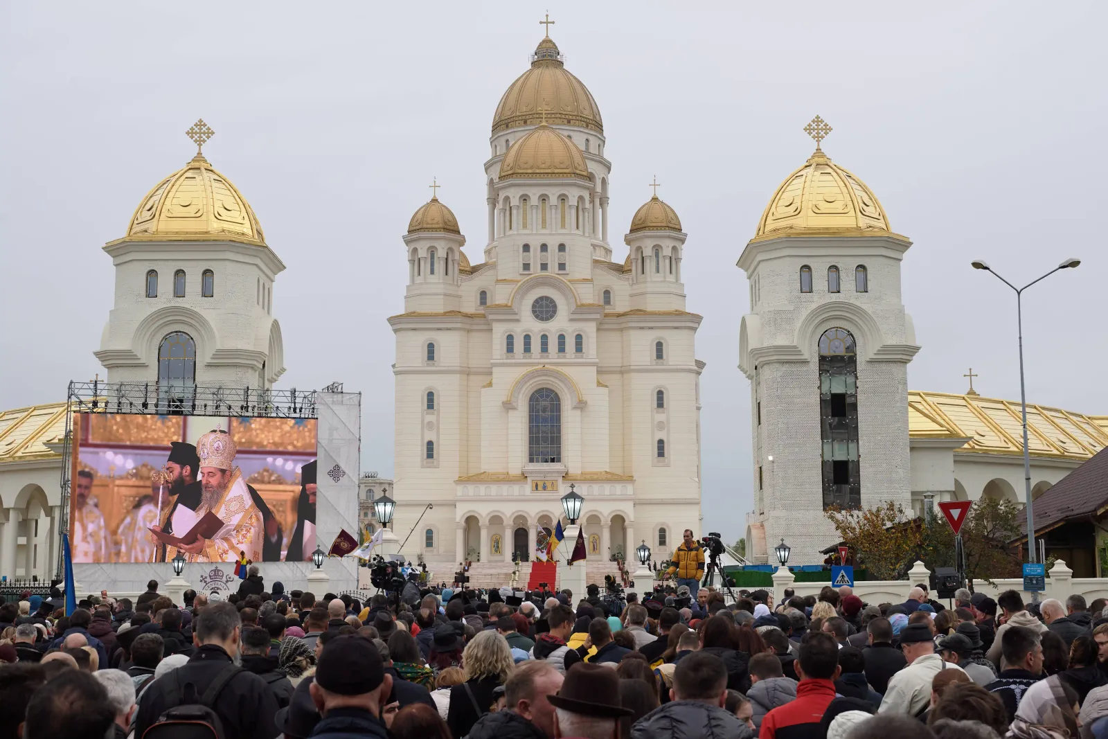 O mulțime de oameni adunați în fața unei catedrale impunătoare.