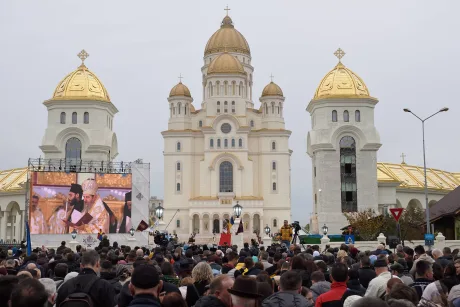 O mulțime de oameni adunați în fața unei catedrale impunătoare.