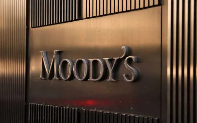 Logo-ul agenției de rating Moody's pe un fundal metalic.