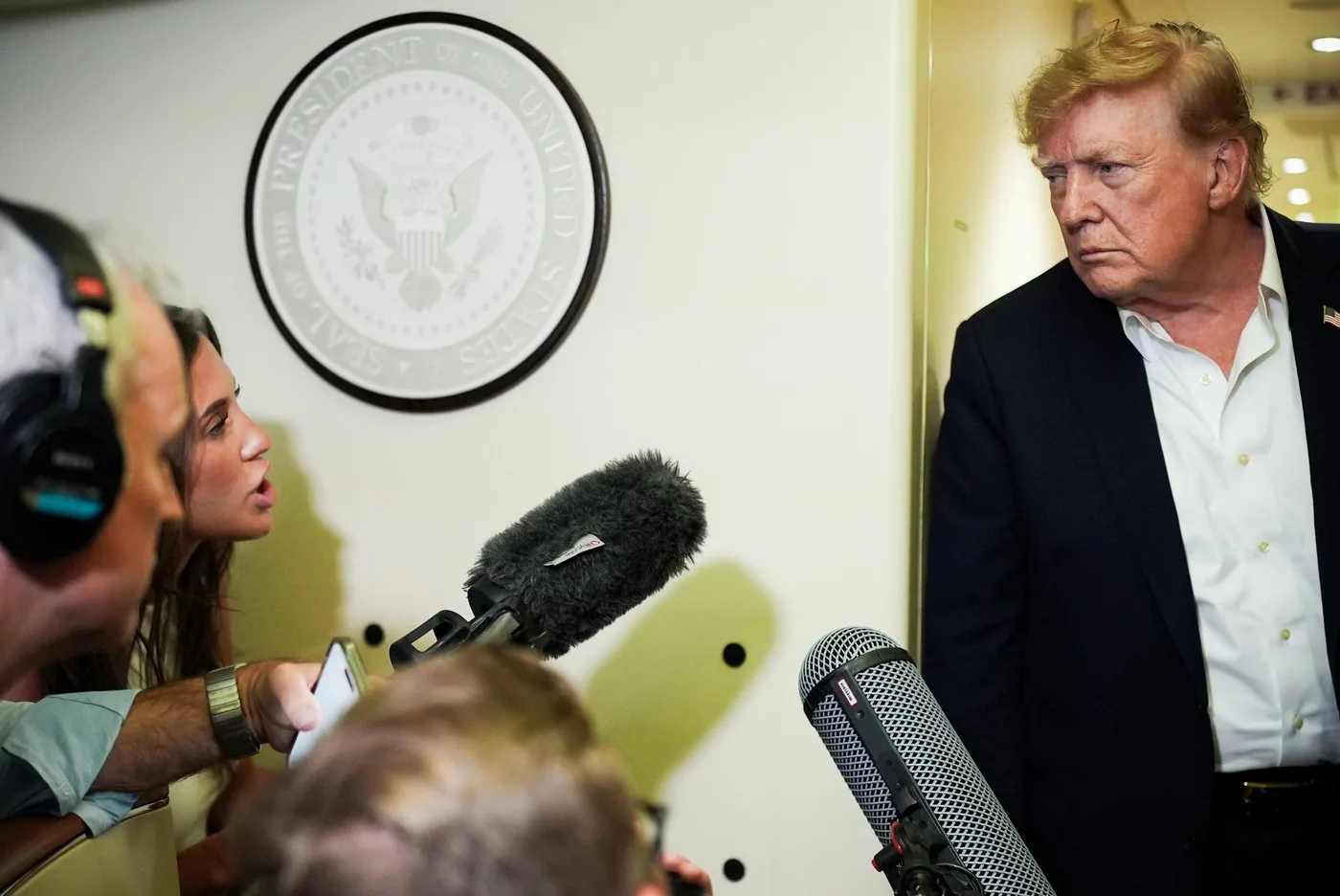 Beni Rae Harmony discutând cu Donald Trump în timpul unei conferințe de presă.