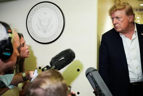 Beni Rae Harmony discutând cu Donald Trump în timpul unei conferințe de presă.