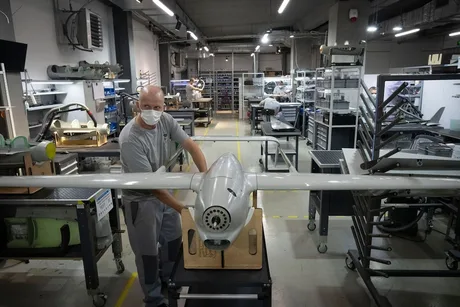 Un tehnician lucrează la asamblarea unei drone în atelier.
