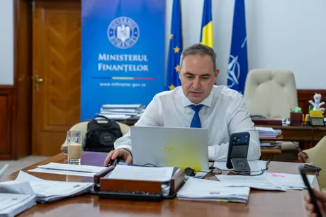 Ministrul Finanțelor discutând despre evaluarea Moody’s în biroul său.