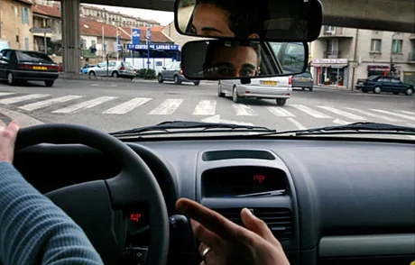 Șofer în trafic, semnalizând o manevră pe o stradă din București.