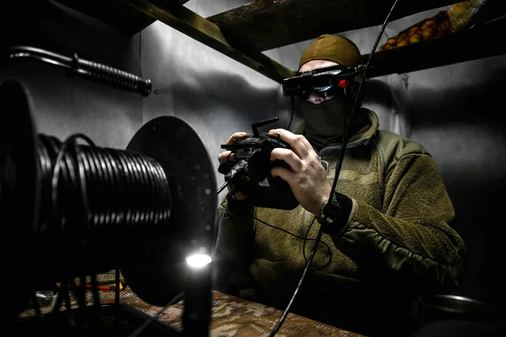 Un bărbat controlează un dispozitiv, într-un mediu de lucru tehnic.