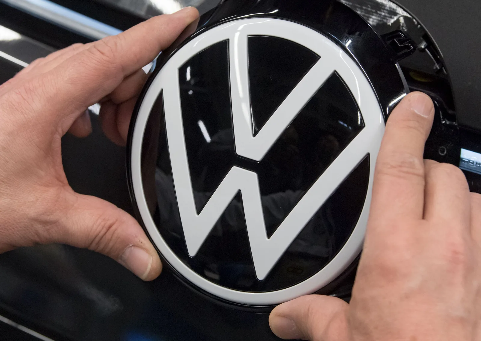 Logo Volkswagen aplicat pe un vehicul, simbolizând schimbările strategice ale companiei.