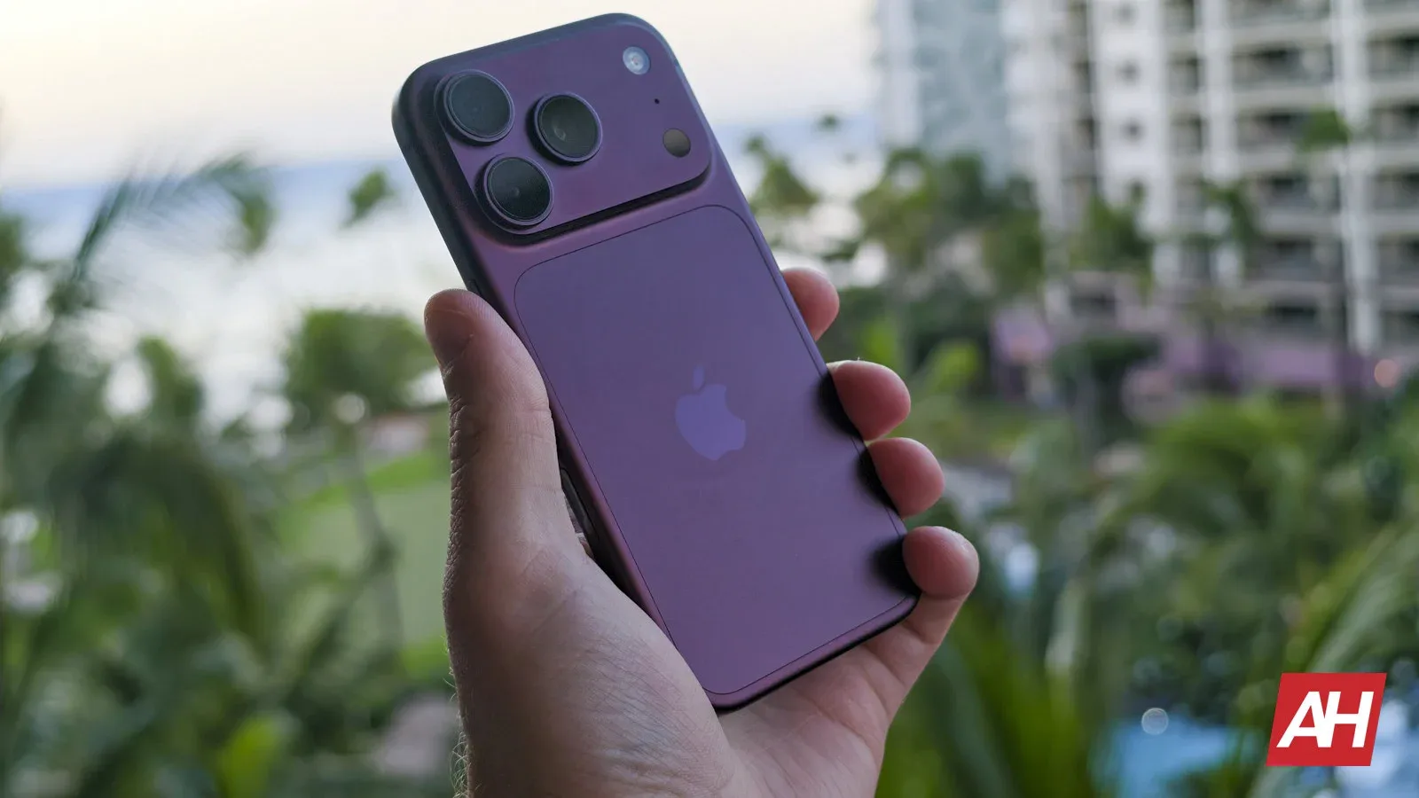 Un smartphone Apple cu un design elegant, în nuanțe de violet, pe fundal natural.