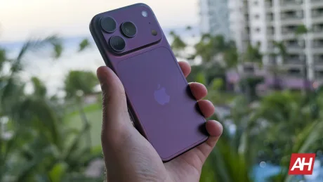 Un smartphone Apple cu un design elegant, în nuanțe de violet, pe fundal natural.