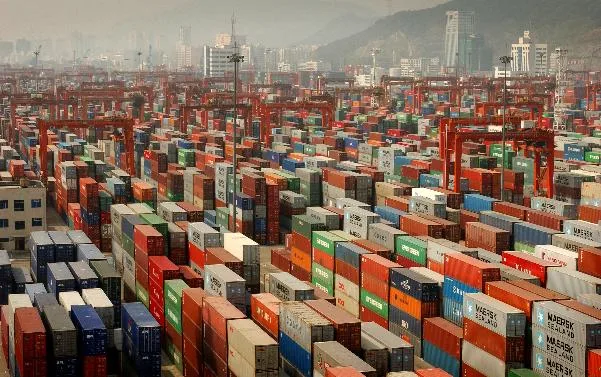 Containere de marfă stivuite într-un port chinezesc, simbolizând comerțul internațional.