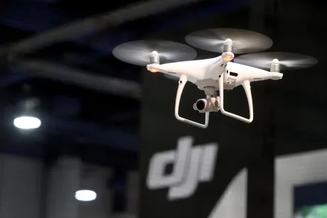 Dronă zburând într-un spațiu expozițional, cu fundal tehnologic.