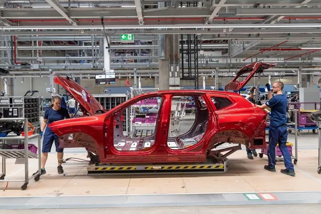 Lucrători la asamblarea unui automobil electric în uzina BMW din Debrecen.