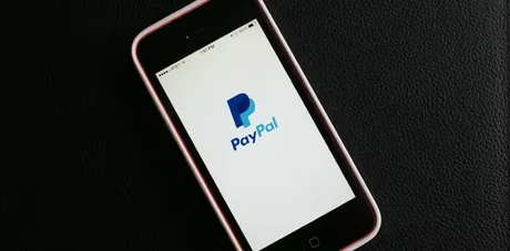 Logo-ul PayPal pe un telefon mobil, simbolizând plățile online.