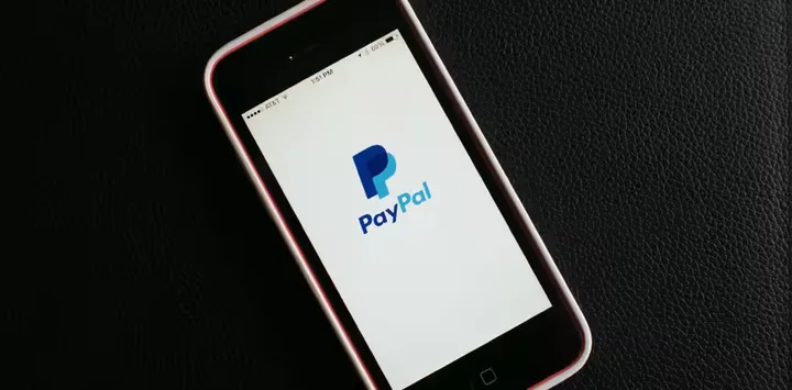 Logo-ul PayPal pe un telefon mobil, simbolizând plățile online.