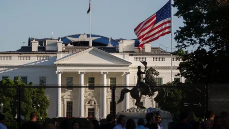 Vedere a Casei Albe cu steagul american fluturând în față.
