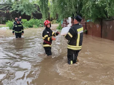 Intervenții ale echipelor de salvare în zone inundate, cu apă până la brâu.