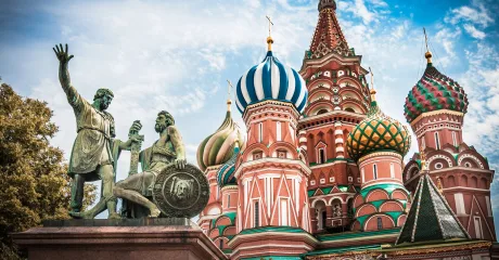 Statuia unui războinic lângă catedrala cu cupole colorate din Moscova.