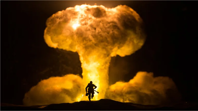 Explozie nucleară cu fum și flacără intensă în fundal.