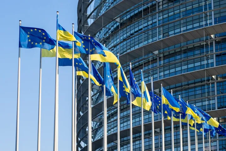 Steaguri ale Uniunii Europene și Ucrainei fluturând în fața unei clădiri moderne.