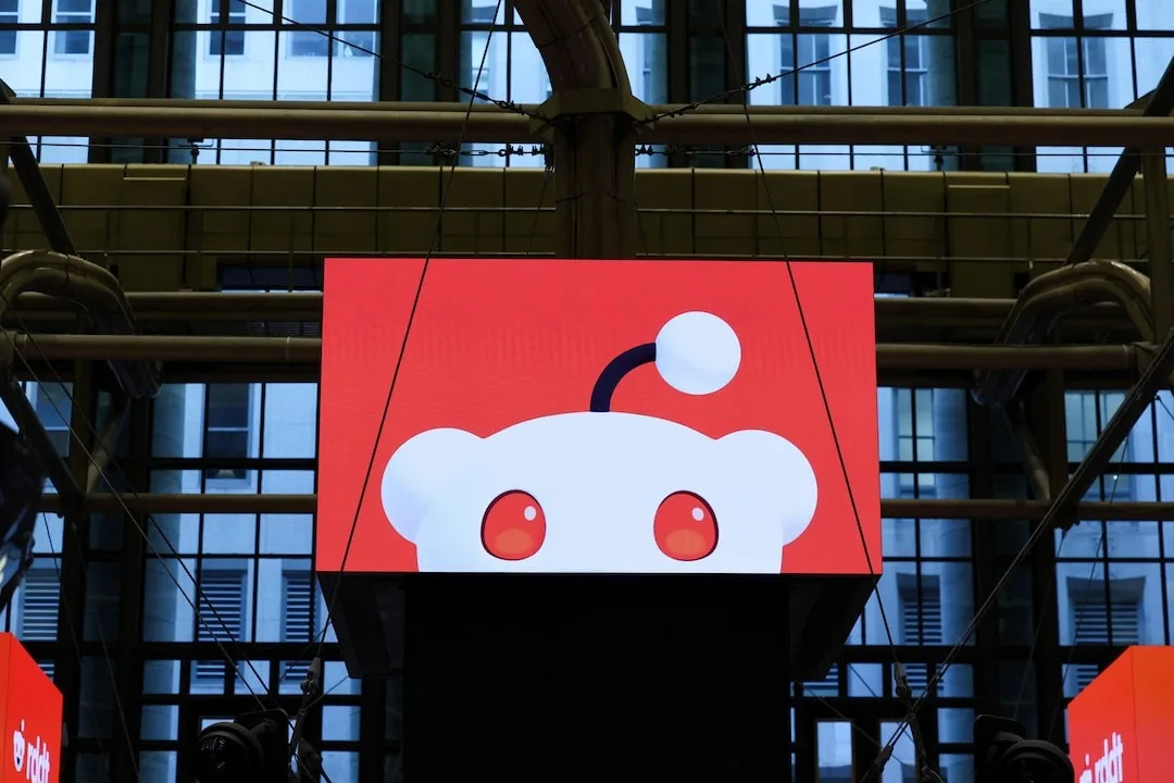 Logo-ul Reddit pe un ecran mare într-un mediu urban modern.
