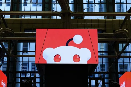 Logo-ul Reddit pe un ecran mare într-un mediu urban modern.