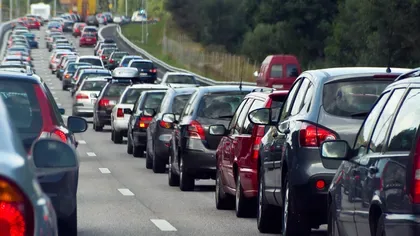 Mașini parcate pe o autostradă aglomerată, semn al cererii crescute.