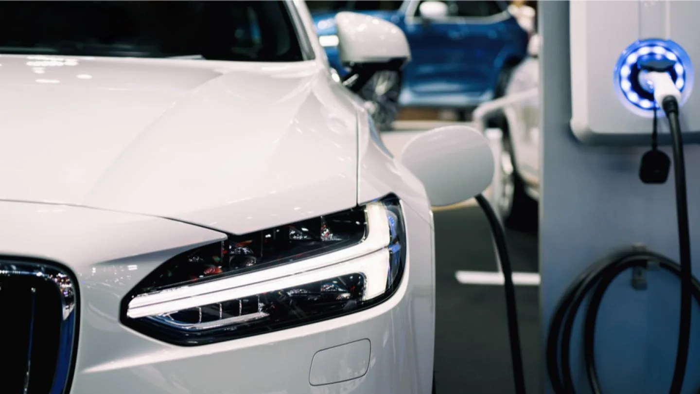 Mașină electrică conectată la o stație de încărcare, simbolizând tranziția ecologică.