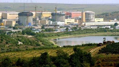 Centrala nucleară de la Cernavodă și Dunărea în fundal, peisaj rural.