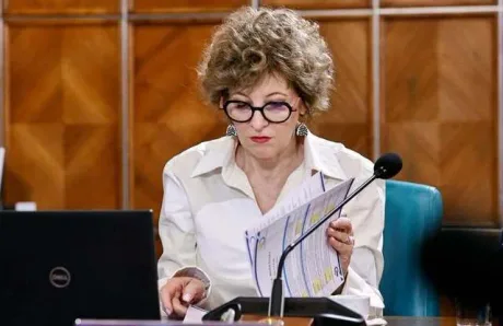 Oana Gheorghiu analizând documente legate de listarea companiilor.