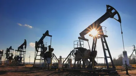 Pompe de extracție a petrolului în lumina soarelui, simbol al crizei energetice.